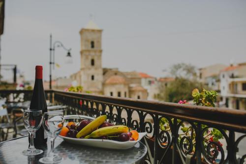 un plato de fruta en una mesa en un balcón en Alkisti City Hotel, en Lárnaca