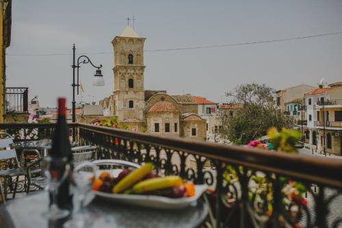 a plate of fruit on a table on a balcony at Alkisti City Hotel in Larnaka