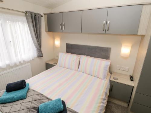 a small bedroom with a bed and a window at Lazy Daze in Bridlington
