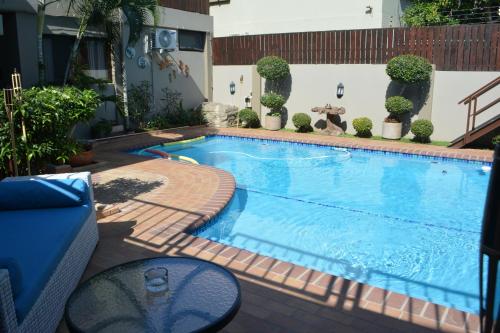 a swimming pool with a brick walkway around it at GuestHouse 1109 in Maputo