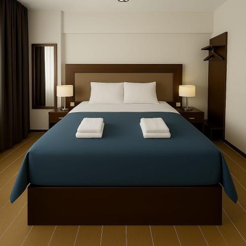 a bedroom with a large blue bed with two towels at Leopard edirne in Edirne