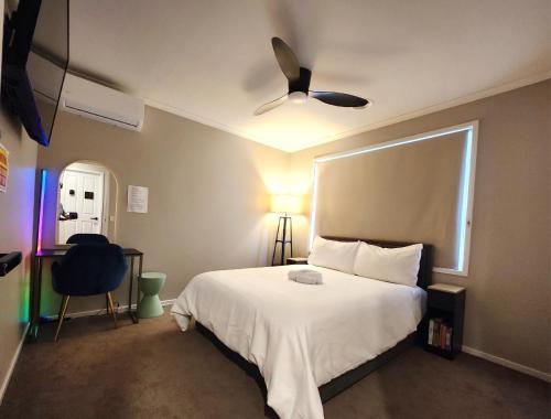 a bedroom with a white bed with a ceiling fan at Private Room 3- The Smart Stay in Craigieburn