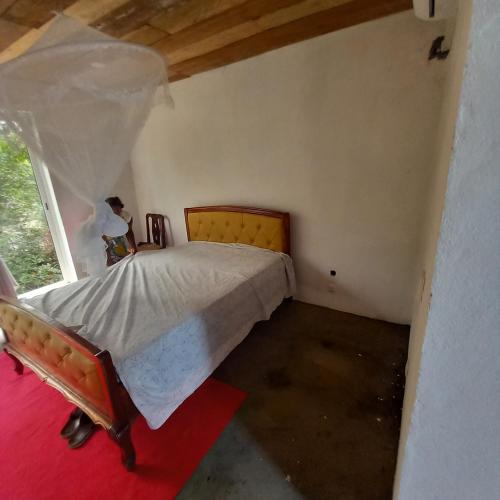 ein Schlafzimmer mit einem Bett in einem Zimmer mit Fenster in der Unterkunft Mionga in Santa Cruz