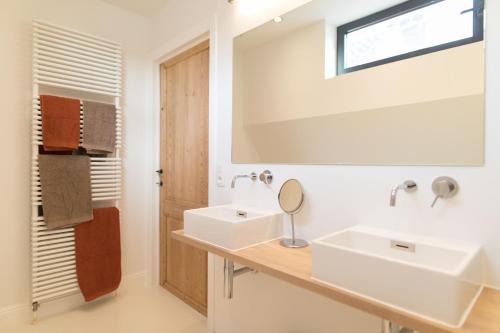 uma casa de banho com 2 lavatórios e um espelho em Hof Van Spanje em Gent