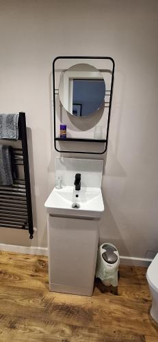 a bathroom with a white sink and a mirror at CeolMara in Ullapool