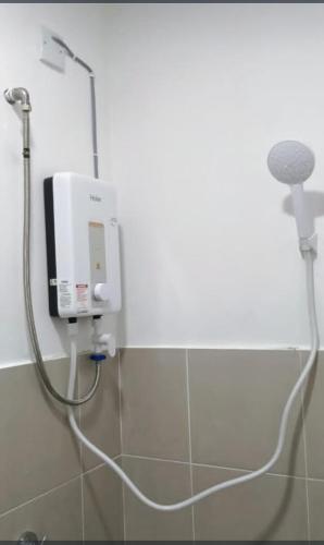 a shower in a bathroom with a hose at D'Tarbiyyah Homestay in Labu