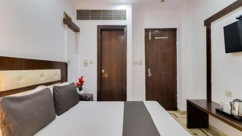 a bedroom with a large bed and a television at Hotel Parth Palace in New Delhi
