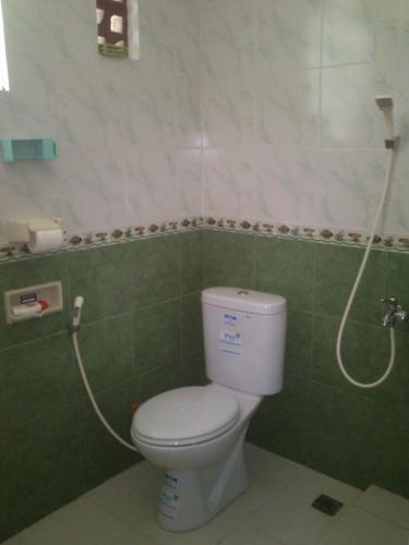 a bathroom with a toilet and a shower at Griya Harja Homestay in Borobudur