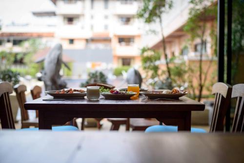 une table en bois avec deux assiettes de nourriture dans l'établissement Srisuksant Resort, à Ao Nang Beach