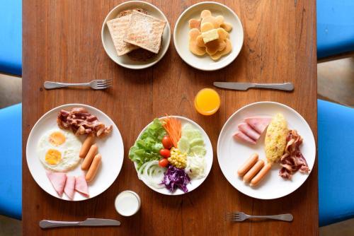 une table en bois avec des assiettes de nourriture dessus dans l'établissement Srisuksant Resort, à Ao Nang Beach
