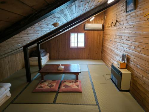 an attic room with a table and a bunk bed at A Lucky Hostel in Hakuba