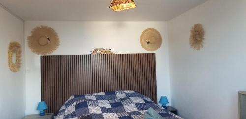 a bedroom with a bed and hats on the wall at Chez Gigi in Petite Île