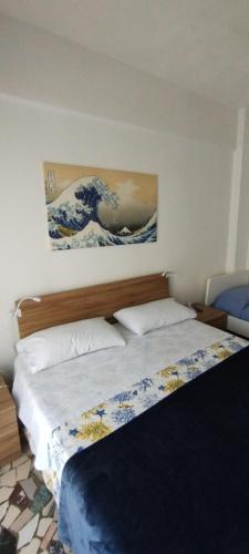 a bedroom with a bed with a painting on the wall at nonna flo in Monterosso al Mare