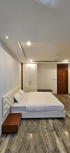a bedroom with a large bed and a wooden floor at Barkah inn in Kannur