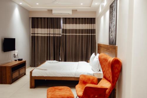 a bedroom with a bed and a chair at Capetown Shaadows in Igatpuri