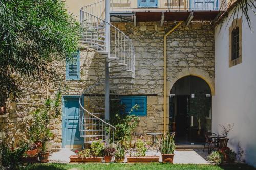 a stone house with blue doors and stairs at Alkisti City Hotel in Larnaka