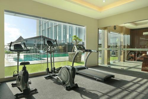 a gym with two exercise bikes and a large window at Swiss-Belinn Saripetojo Solo in Solo