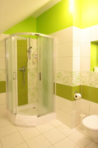a bathroom with a shower and a toilet at Matrioszka Pokoje Hotelowe in Gołdap