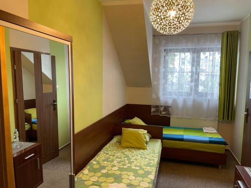 a small room with a bed and a mirror at Matrioszka Pokoje Hotelowe in Gołdap