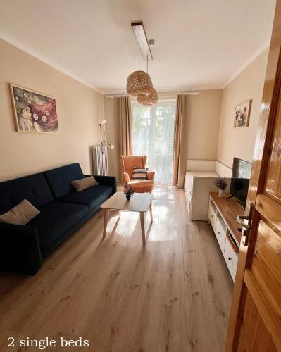 a living room with a blue couch and a table at Akacja Centrum Apartament in Rzeszów