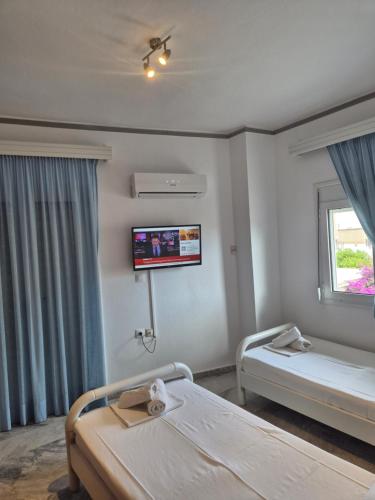 a hospital room with two beds and a flat screen tv at Varmy in Ierapetra
