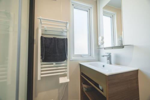 a bathroom with a sink and a window at Camping Le Malazéou Wellness Sport Camping in Ax-les-Thermes