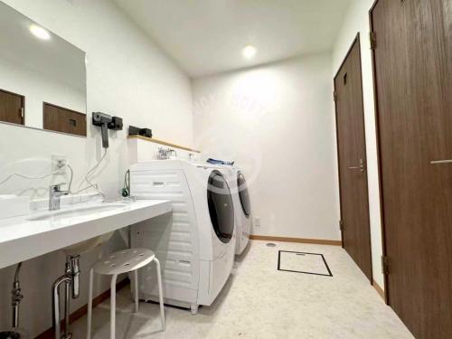 a white room with a tv and a sink at A Lucky Hostel in Hakuba