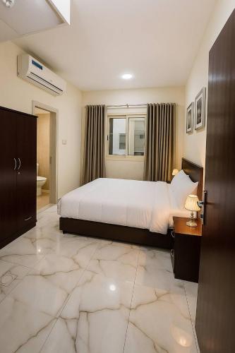 a bedroom with a large white bed and a room with at Cozy Studio Apartment near union Metro in Dubai