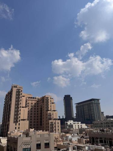 a city skyline with tall buildings and a cloudy sky at Cozy Studio Apartment near union Metro in Dubai