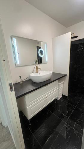 a bathroom with a sink and a mirror at Hyggelig lejlighed tæt på motorvej og Odense Zoo in Odense