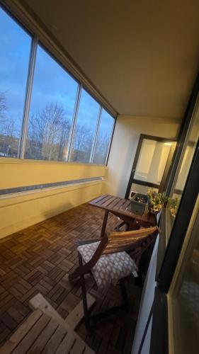 a room with a table and a bench and windows at Hyggelig lejlighed tæt på motorvej og Odense Zoo in Odense