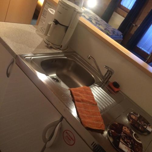 a kitchen sink with an orange towel in it at Ferienwohnungen Marchanger in Niederau