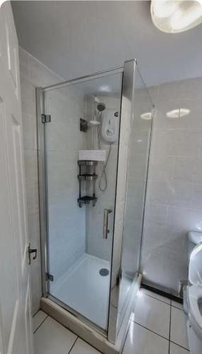 a shower with a glass door in a bathroom at Lovely studio-flat with free parking, free WiFi. in Leeds