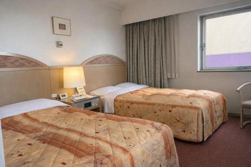 a hotel room with two beds and a window at ホテルサンモール in Asahi