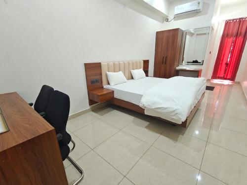 a bedroom with a bed and a desk and a desk at Hotel Nandaashish in Haldwāni