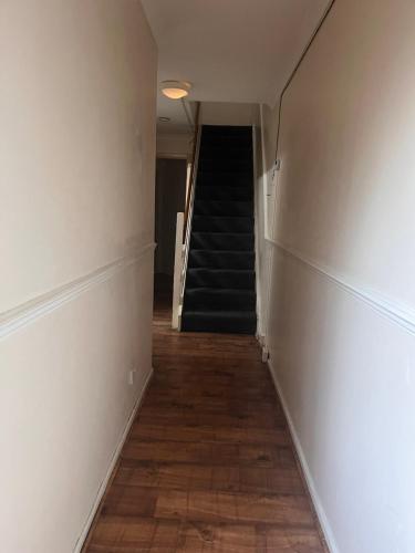 an empty hallway with a staircase and a stair case at Lewisham Rooms in London
