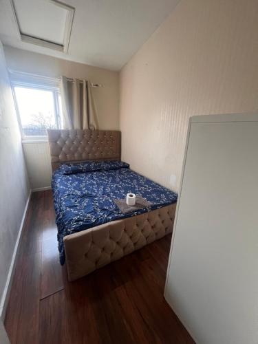 a small bedroom with a bed with a cup on it at Lewisham Rooms in London