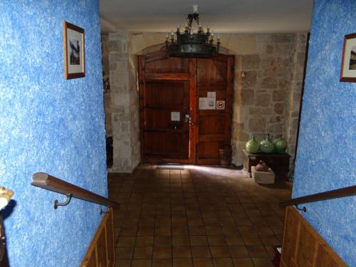 a hallway with blue walls and a wooden door at La Hacienda de mi Señor in Lerma