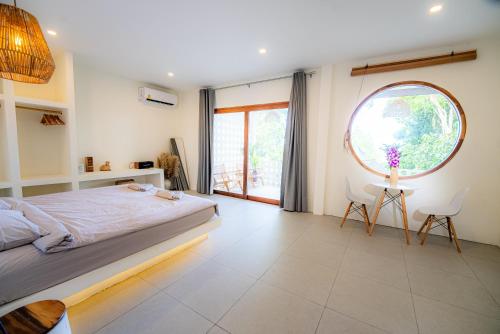 a bedroom with a large bed and a large window at Crocus Garden in Haad Yao