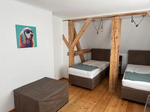 a room with two beds and a painting of a dog at ApartMENTZ - Zimmervermietung in Sankt Peter ob Judenburg