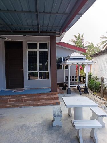 a house with a picnic table in front of it at D'Yaya Homestay in Kampong Pengkalan Nyireh