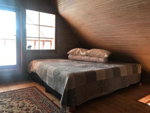 a bedroom with a bed with two pillows on it at Ala-Kure metsamaja in Varbuse