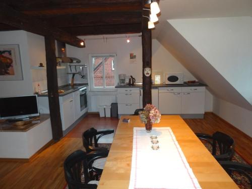 a dining room with a table and a kitchen at Havelhof-Nitzow in Nitzow