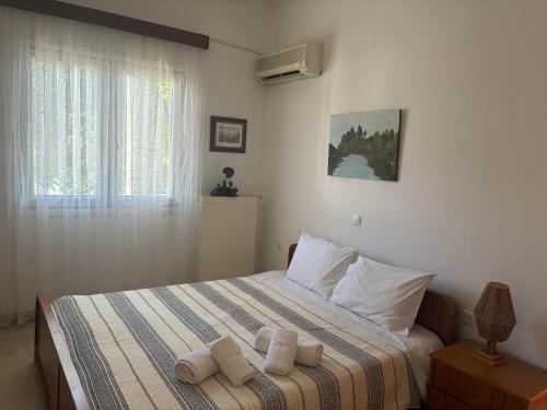 a bedroom with a bed with towels on it at Reposo in Nikolítsion