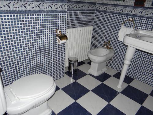 a blue and white bathroom with a toilet and sink at La Hacienda de mi Señor in Lerma