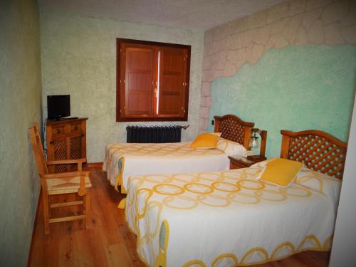 a hotel room with two beds and a television at La Hacienda de mi Señor in Lerma