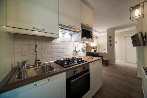 a kitchen with a sink and a stove at Residence Lungomare - Charming apartments in Riccione