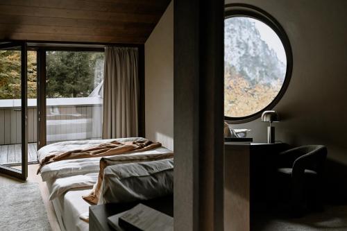 a bedroom with two beds and a large window at BAUA Gartenhaus in Maurach