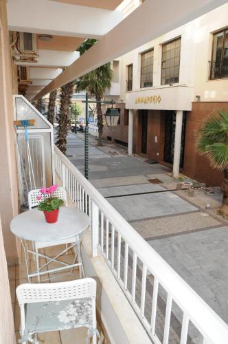 a balcony of a building with a table and chairs at Sunset by the sea 2 in Loutraki