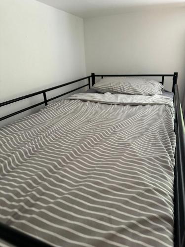 an unmade bed in a white room at Lewisham Rooms in London